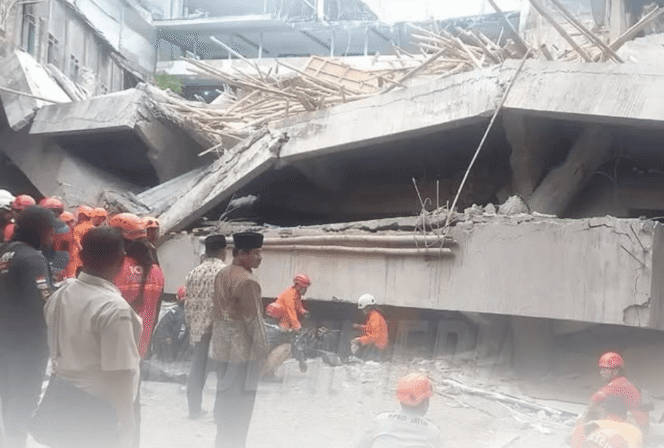 
					Petugas gabungan TNI-Polri dan relawan BPBD mengevakuasi material bangunan yang ambruk. (Sumber: divisihumaspolri)